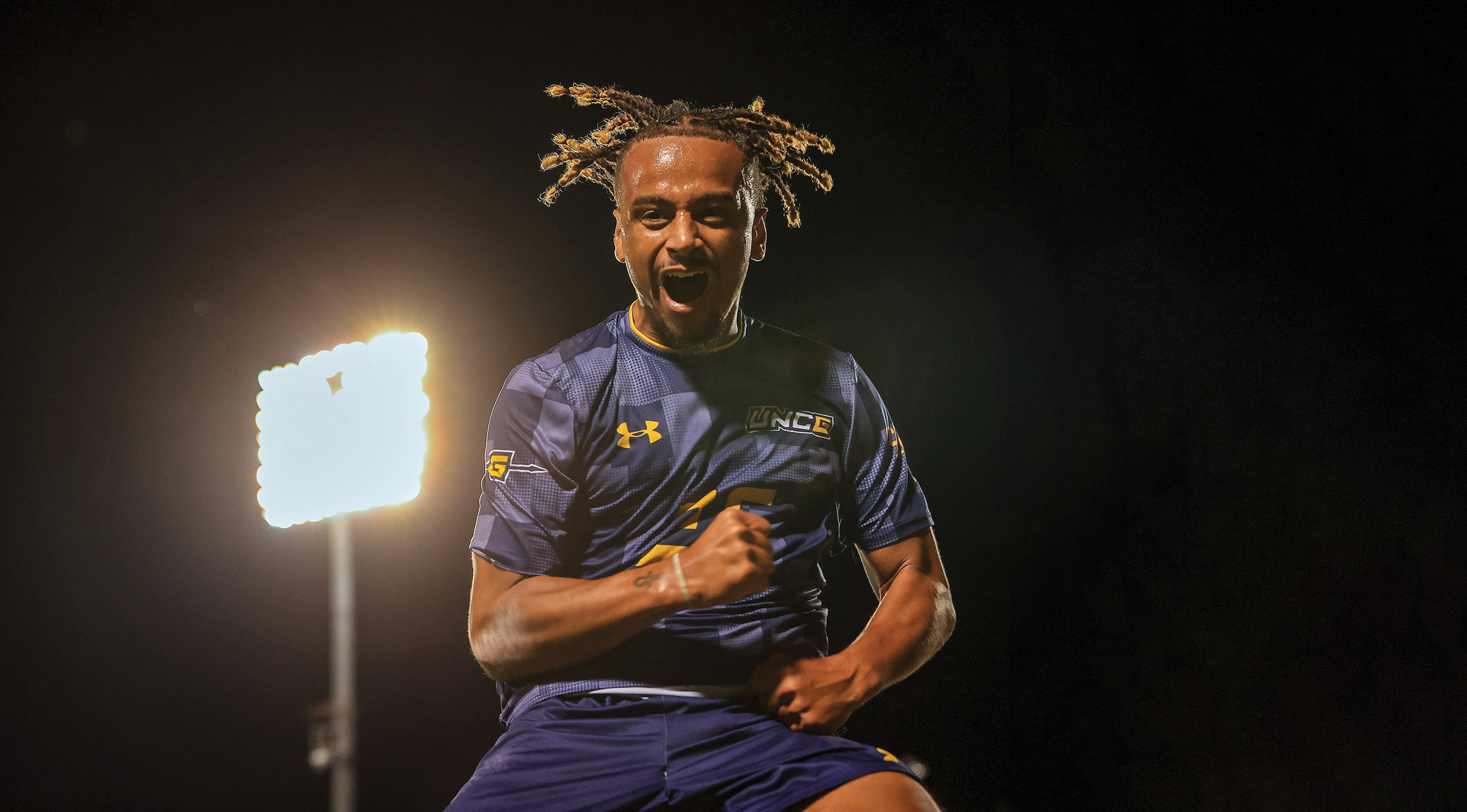 A young soccer player jumping in the air to celebrate.
